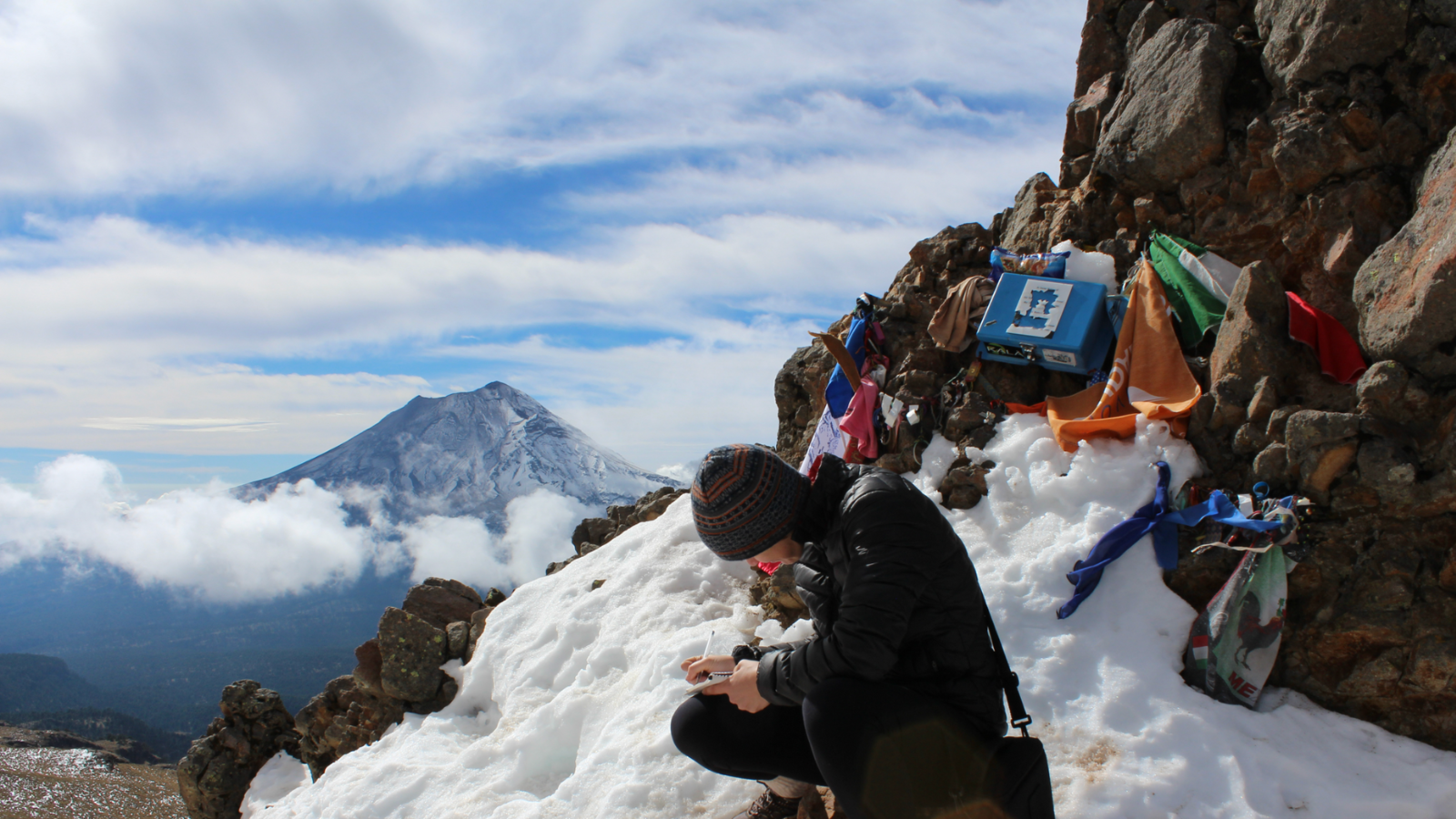 Researcher writing on a mountain side 