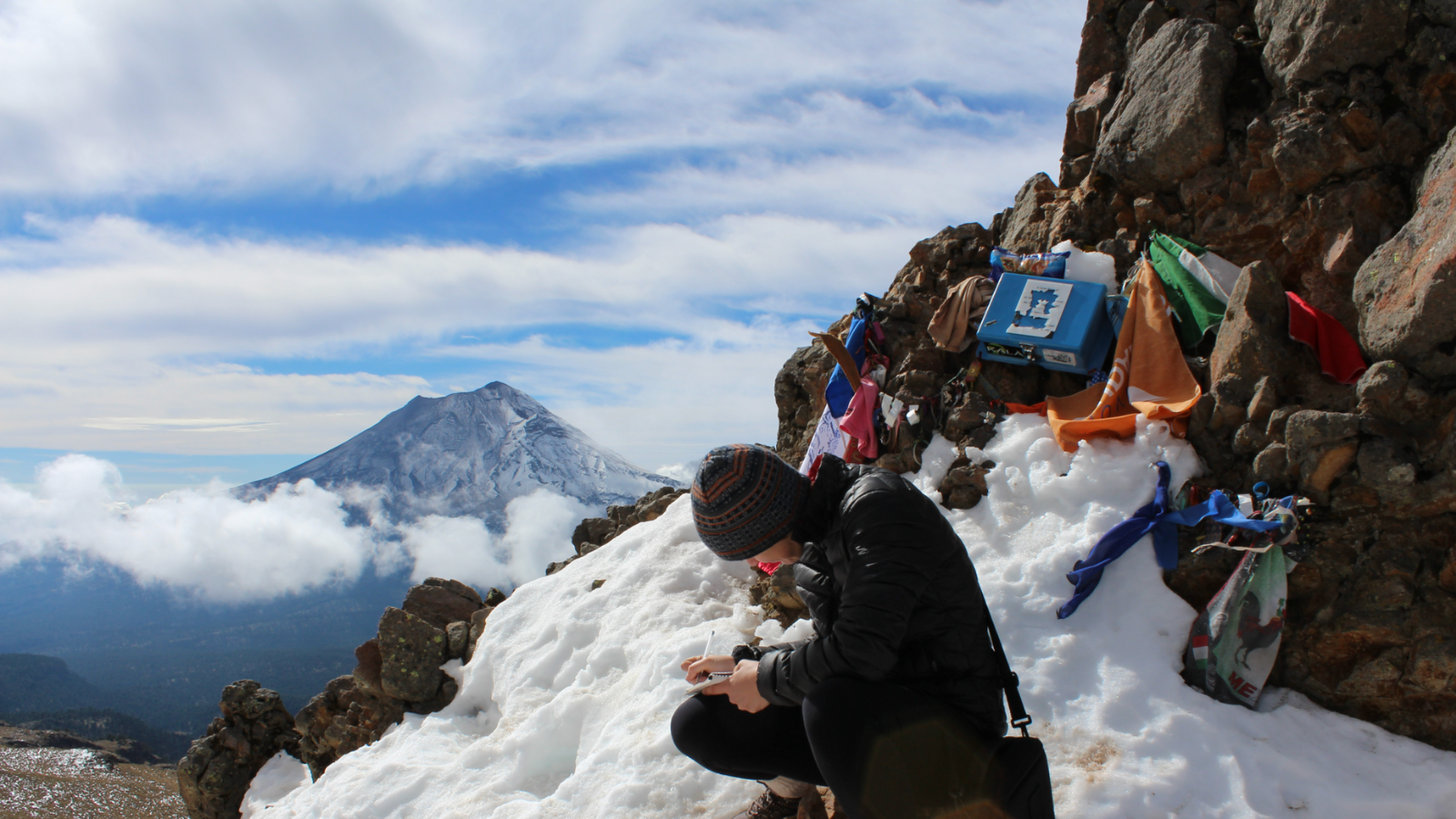 Researcher writing on a mountain side