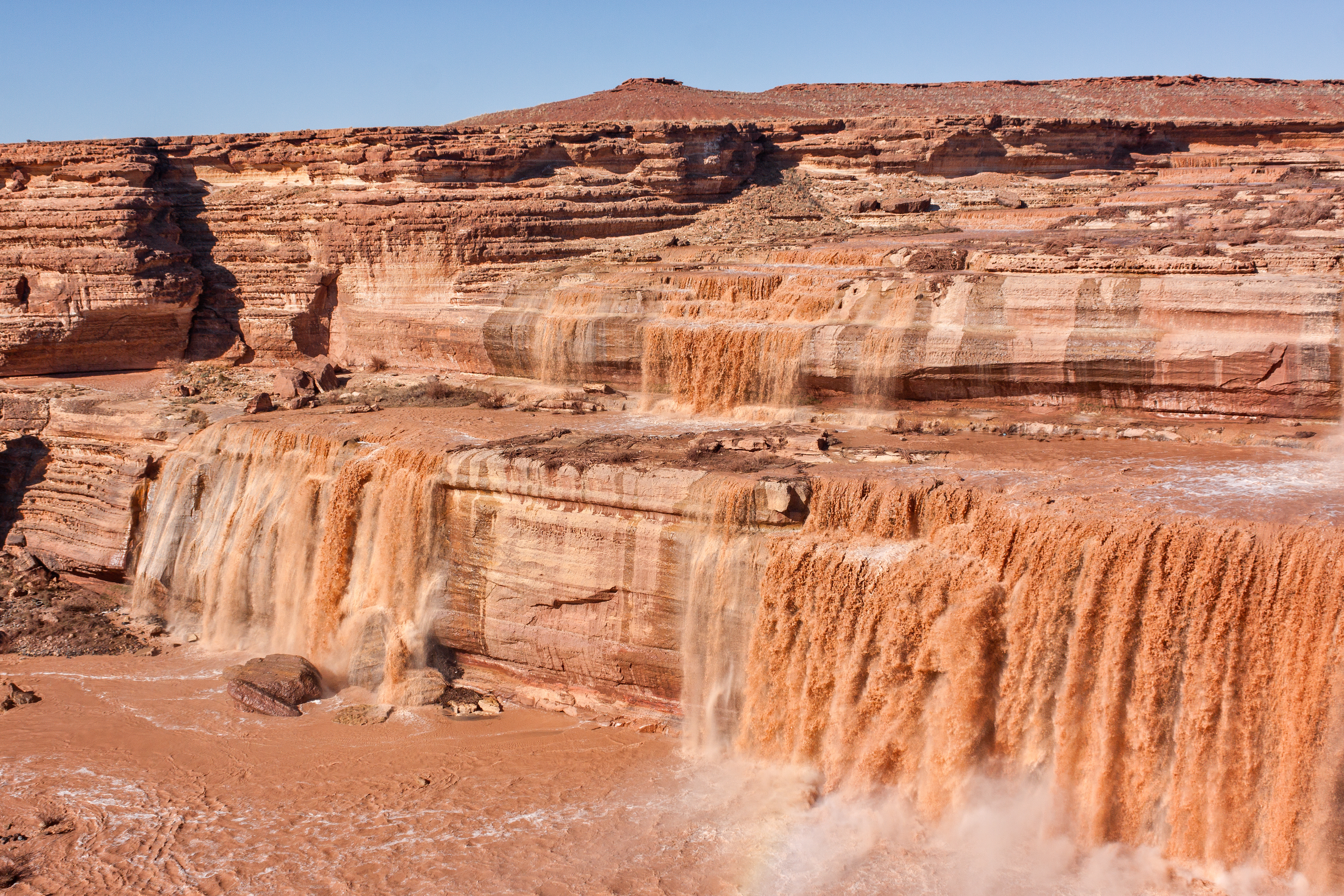 River flowing over red rock, small waterfalls visible
