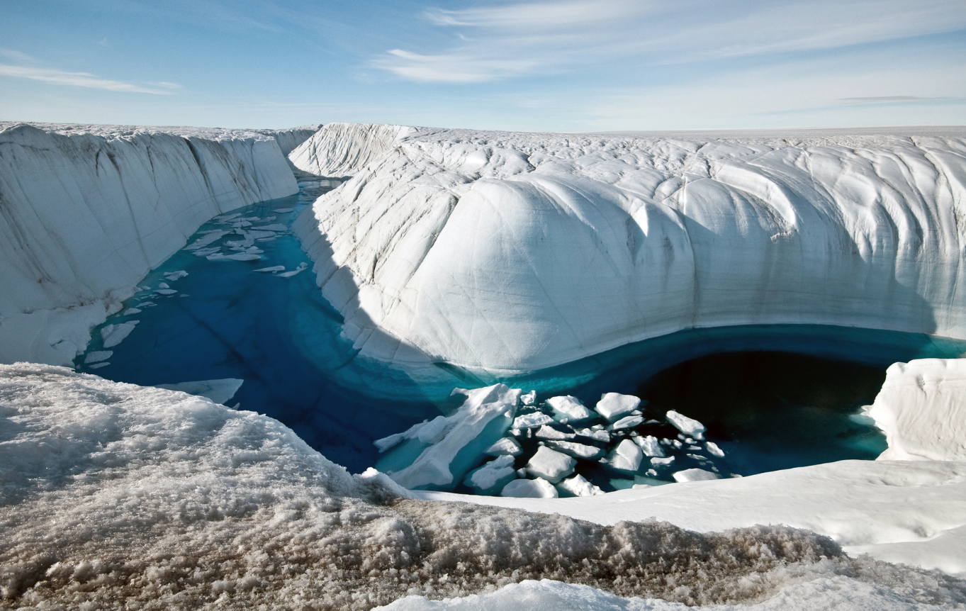 River going through a channel in between a glacier, water is dark blue