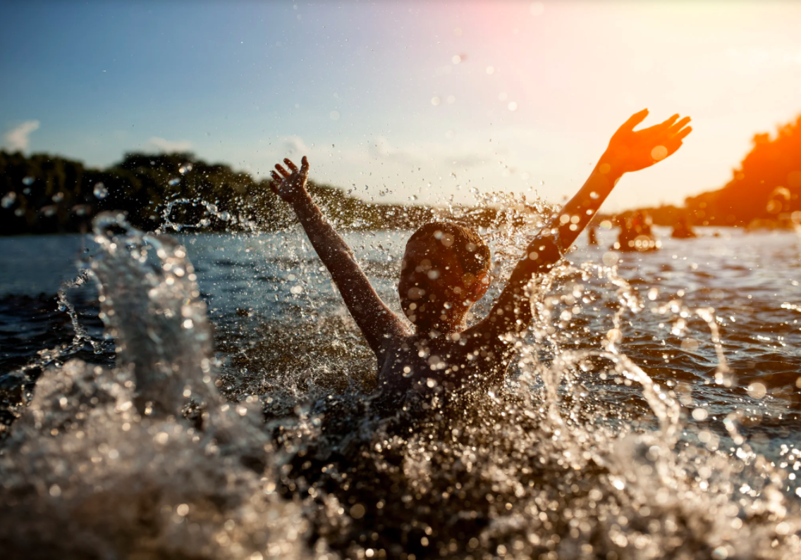 chil splashing in a lake water drops slashing in the for front sunset