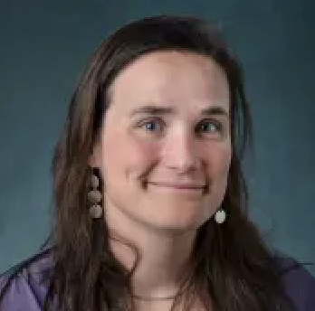 Dr. Jen Kay smiling at camera with dark blue background