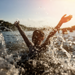 Child splashing and playing in a body of water