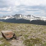 Rocky Mountain National Park; rock in the forefront with snowy peaked mountains in the background