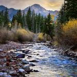 River running through the mountains, mountain peak in the back, fall time