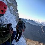 Ryan Vachon filming a climber on the side of a snowy mountain