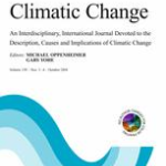Cover of the scientific journal Climatic Change. The title appears in large serif font at the top of a white background, followed by a brief subtitle. Below, an abstract wave pattern in shades of blue and teal curves upward from the edges. Minimalist and professional design
