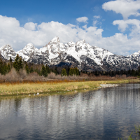 Skyline of the mountains with a river in the front.