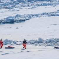 Researchers walk on the ice in the Antarctic.