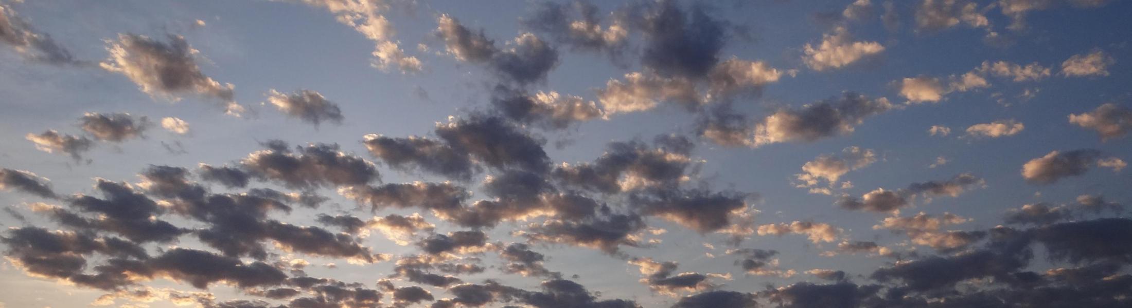 sun set illuminates clouds over a lake