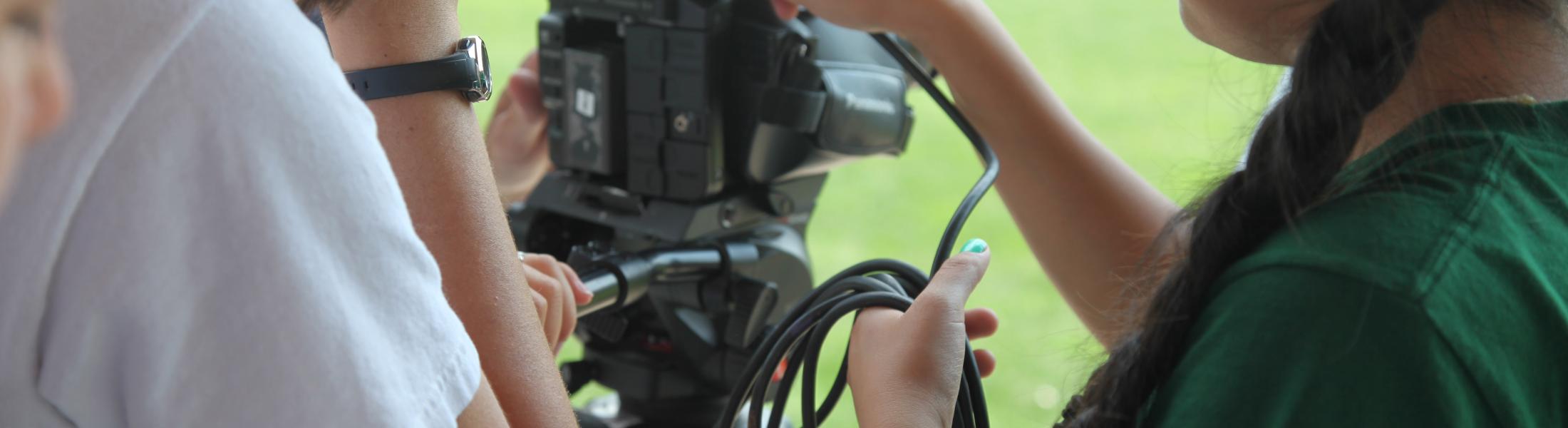 students gather around video equipment