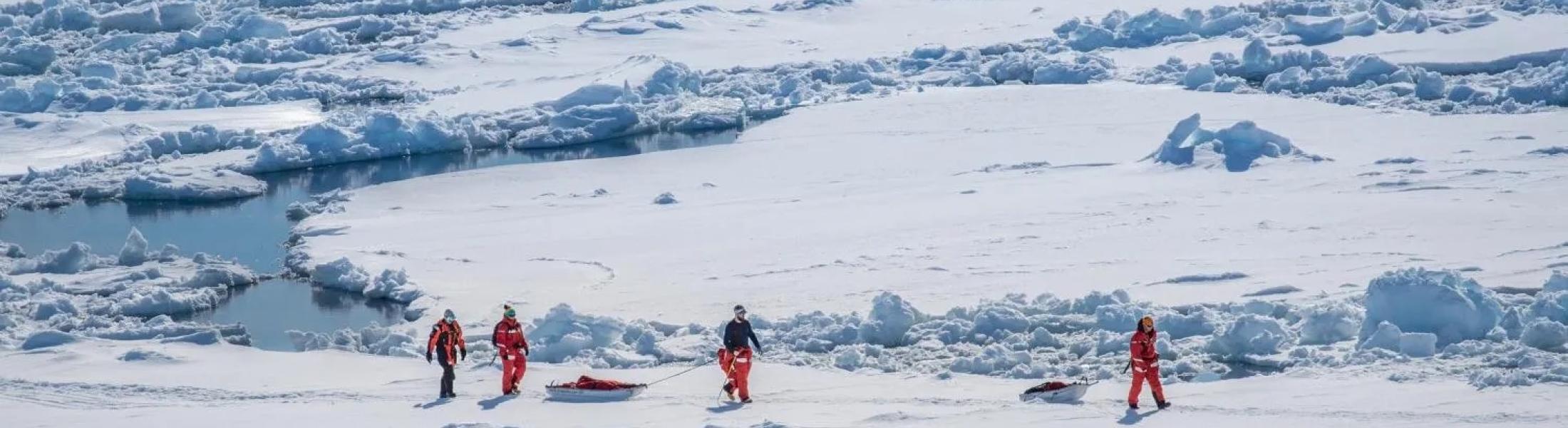 Researchers walk on the ice in the Antarctic.