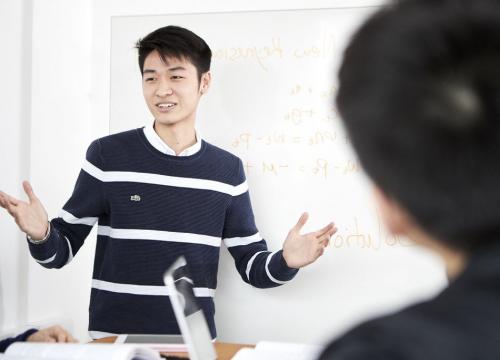 A student stands while doing a presentation.