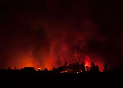 The Spring Creek Fire breaks over La Veta Pass, July by Defense Visual Information Distribution Service. Red wildfire with smoke coming up from it in the dark. 