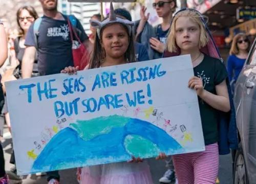 Image of girls holding climate sign.