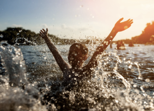 Child splashing and playing in a body of water