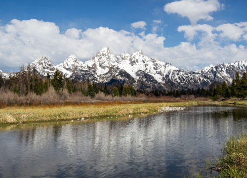 Skyline of the mountains with a river in the front.
