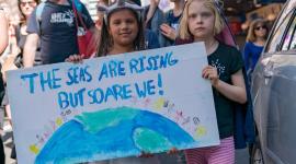 The seas are rising and so are we children holding up poster