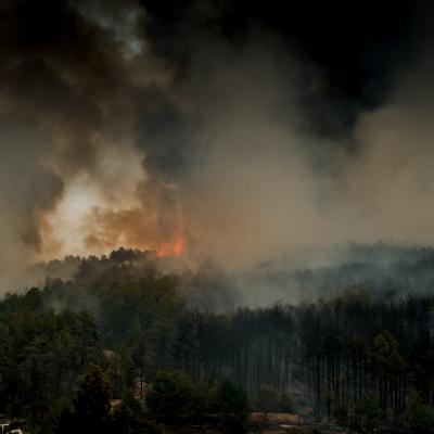 Wildfire on a mountain range with lots of smoke