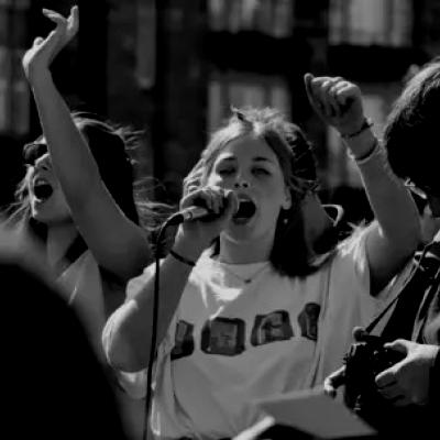 Black and white image protest with girl speaking into microphone