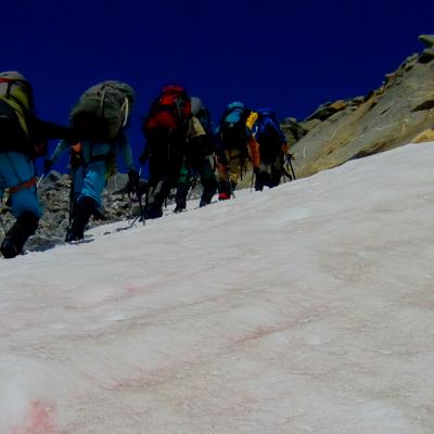 Field team walking up a glacier with climbing gear