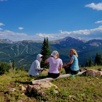 Girls sitting on side of mountain