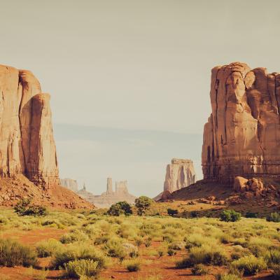 Two table top mountains in Utah with green field in between it