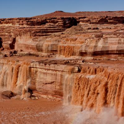 River flowing over red rock, small waterfalls visible