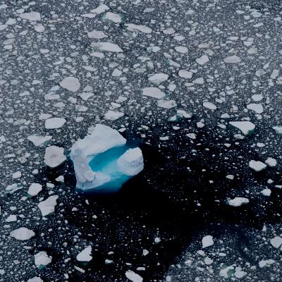 Iceberg and broken pieces of an ice berg floating in the ocean