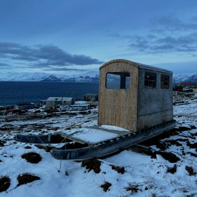 House boat on snowy shore near ocean 