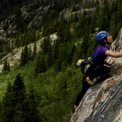 Girl climbing the side of a mountain