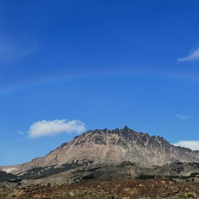 Rainbow over mountain range with blue skys 