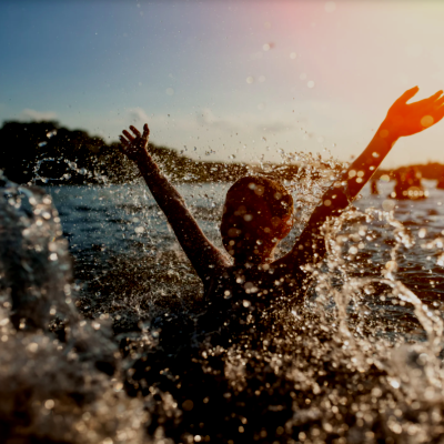 chil splashing in a lake water drops slashing in the for front sunset