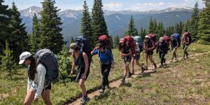 Group of women hiking along a trail wearing backpacks