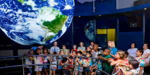 Crowd of children and adults looks at the SOS exhibit