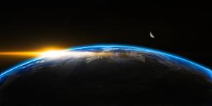 Space image of earth with sun rays on the left of it