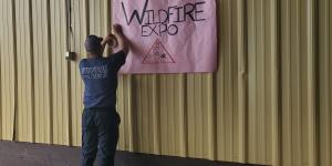 Man hanging sign saying Wildfire Expo