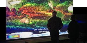 People in dark room looking at a screen with a sea surface temperature map
