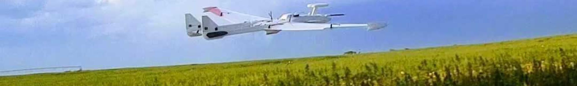 White and red drone flying over a corn field