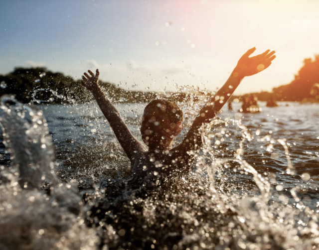 Child splashing and playing in a body of water